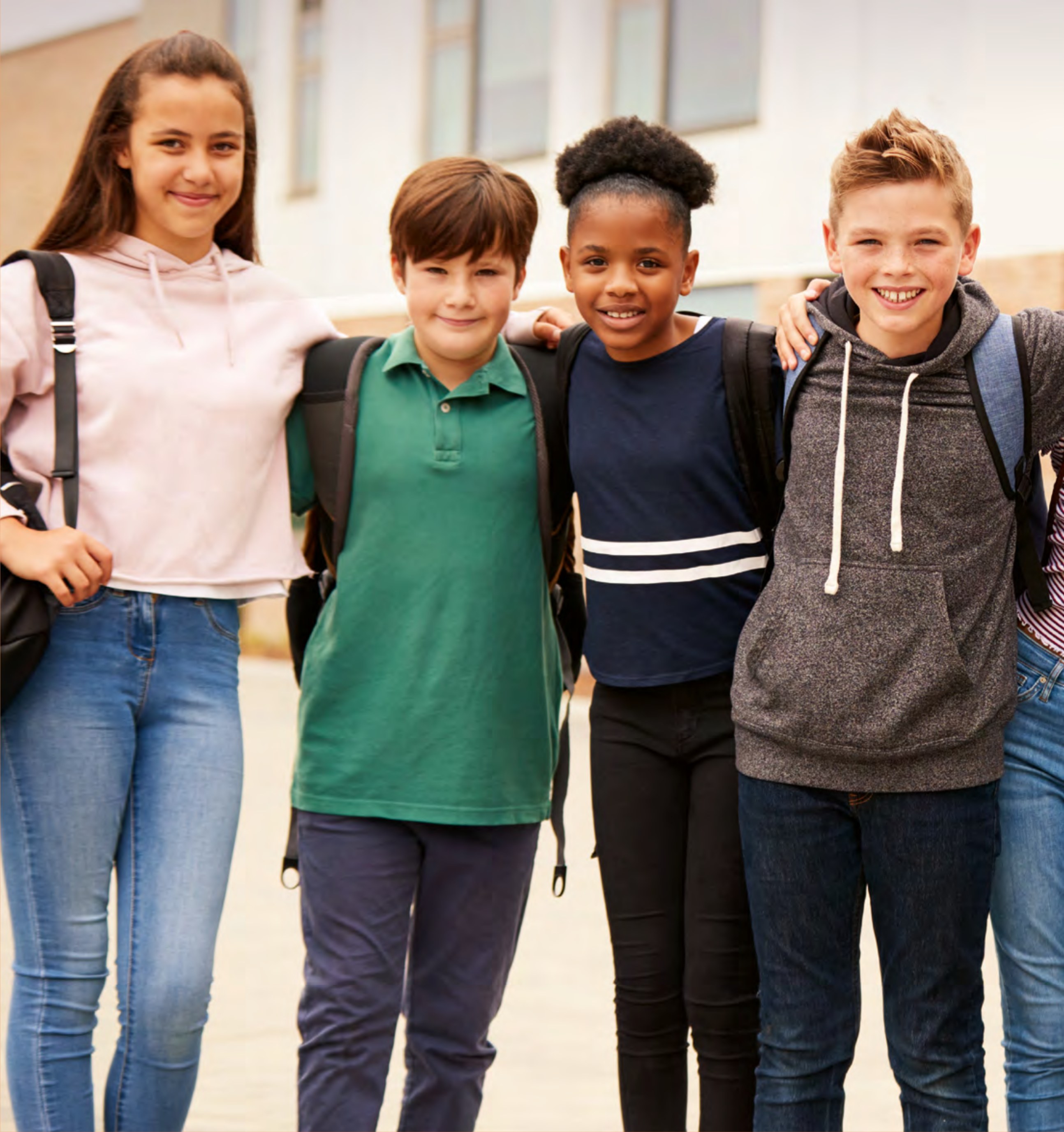 Zwei Jungen und zwei Mädchen schauen freundich in die Kamera